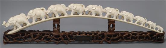 A Chinese carved ivory ten-elephant bridge on pierced carved hardwood stand, L 58cm